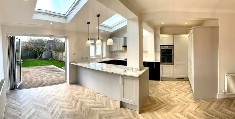 Open-plan kitchen with an island, rooflight and herringbone flooring