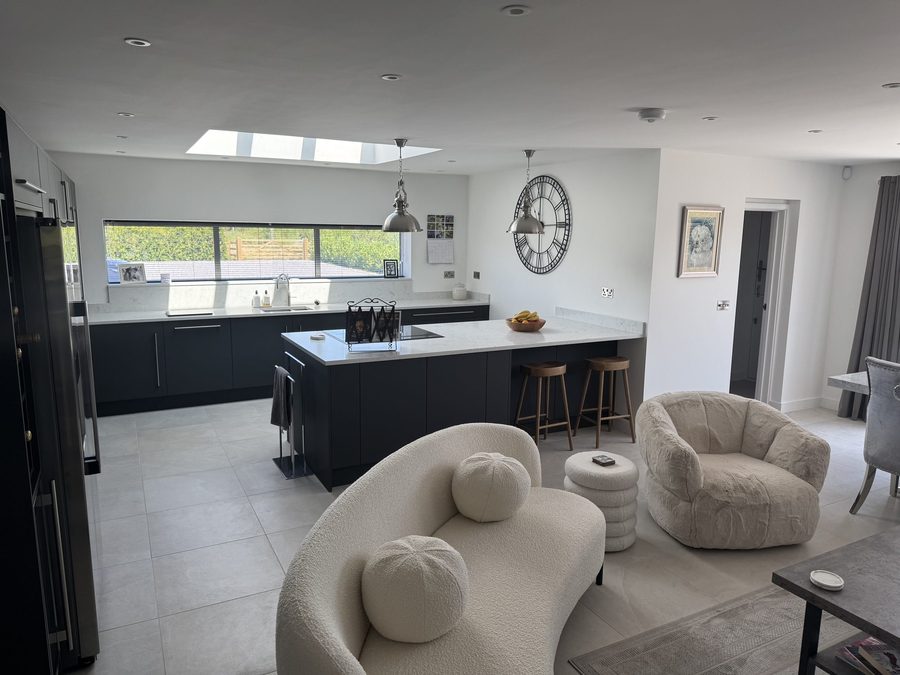 Open-plan kitchen and living space with a rooflight, island and curved seating