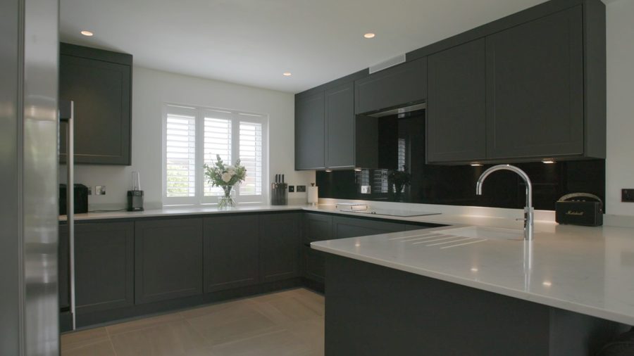 Dark grey kitchen with a large island and integrated appliances